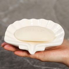 a person holding a soap dish in their hand