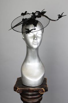 This is a one of a kind piece of wearable art made for the Five and Diamond Seventh Annual Headgear Art Show and shown on August 2, 2019. A delicate sculpture in shadow depicting butterflies and branches balanced atop a romantic disk veil. Designed by Kalico Delafay One of a kind Unisex MATERIALS USEDVeiling, wood, steel wire, wool felt, lacquer. WEARING INSTRUCTIONSCan be worn tilted over either side of face, place with head band, and secure hair pins through hidden elastic loops at edge of bas Headgears For Fashion Show, Elegant Handmade Black Headpiece, Derby Hats Diy Ideas, Derby Hats Diy, Side Of Face, How To Make Fascinators, Floral Headdress, Fashion Illustration Sketches Dresses, Sketches Dresses