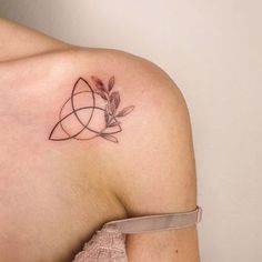 a woman's shoulder with a tattoo design on the left side of her arm