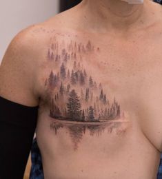 a man with a forest tattoo on his chest