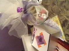 a table topped with boxes filled with cards and other items next to a vase full of flowers