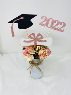 a graduation decoration with flowers in a mason jar