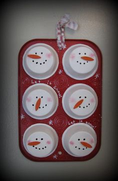 a red tray with four snowmen on it and one is hanging from the wall