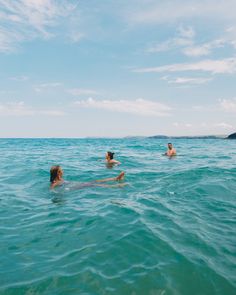 two people swimming in the ocean on their stomachs