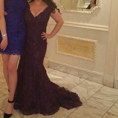 two women standing next to each other in front of a mirror wearing evening gowns