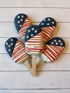 four patriotic lollipops on a wooden stick with white and blue icing