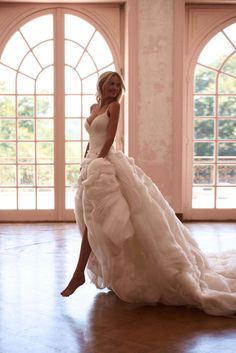 a woman in a wedding dress is posing for the camera