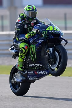 a man riding on the back of a motorcycle down a race track