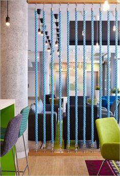 a room with chairs, tables and blue ropes on the wall in front of it