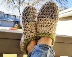 someone is wearing crocheted slippers while sitting on a porch with their feet up