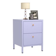 a white night stand with two drawers and a lamp