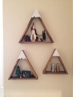 three triangle shaped shelves on the wall with decorations in each one's triangular shape