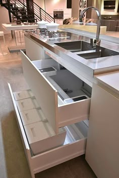 an open drawer in the middle of a kitchen