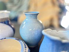 several blue and white vases sitting on top of a table next to each other