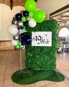 a golf themed centerpiece with balloons and a sign that says the 19 th hole