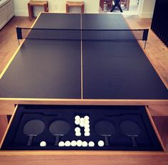 two ping pong tables with white balls in the middle and one black table top