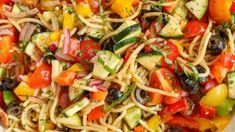 a bowl filled with pasta and vegetables on top of a table