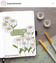 an open notebook with daisies and flowers on it