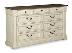 a white dresser with drawers and black handles