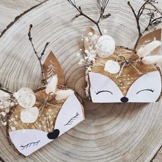 two paper foxes are sitting next to each other on a piece of wood with branches and flowers