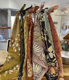 five scarves hanging on a rack in a store