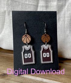 earrings with basketball jersey and hoop hanging from them on a black card board in front of a white sheet