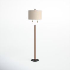 a floor lamp with a white shade on top and a black base, in front of a white background