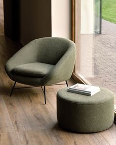 a green chair and ottoman in front of a window