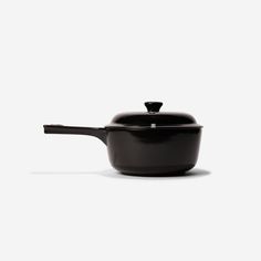 a black pot with a wooden handle on a white background, the lid is slightly open