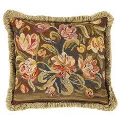 an embroidered pillow with fringes and flowers on the front, sitting on a white background