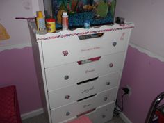 there is a dresser with many drawers in the room and some toys on top of it