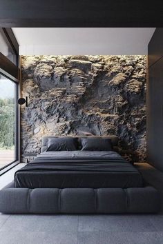 a large bed sitting next to a window in a room with stone walls and flooring