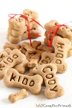 dog biscuits with words written on them and tied in red ribbon sitting next to each other