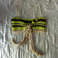 a crocheted green and black purse laying on top of a bed