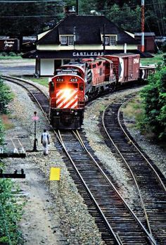 a train traveling down tracks next to a forest