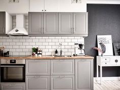 a kitchen with gray cabinets and white tile