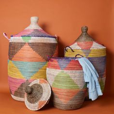 Large size nesting storage basket set with hooded lids in colorful triangles. Large basket measures approx. 17" diameter, 23" without hood, and 30" height with hood. Medium basket measures approx. 15" diameter, 19" without hood and 25" with hood. Small basket measures approx. 12" diameter, 14" without hood, and 20" with hood. For storing laundry, toys and blankets. Woven from grass and recycled plastic ribbons using traditional coil weaving technique. Handmade by Wolof tribe women in Senegal, Af Large Basket With Lid, Hooded Lids, Senegal Africa, Marble Rolling Pin, Small Storage Basket, Colorful Baskets, Pink Basket, Grass Basket, African Crafts