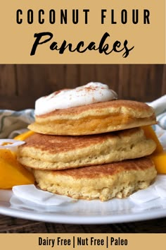 three pancakes stacked on top of each other with whipped cream and orange slices around them