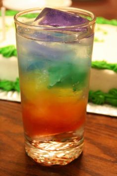 a colorful drink sitting on top of a wooden table