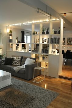 a living room filled with furniture and lots of bookshelves on top of it