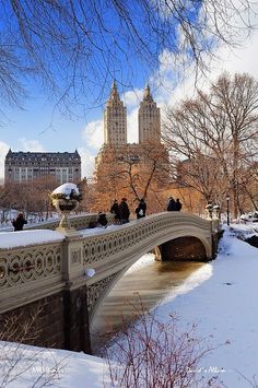 a bridge that has snow on it and people walking over it in the winter time