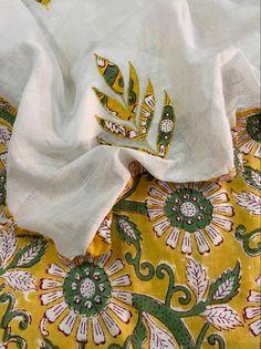 a white and yellow cloth with green designs on it