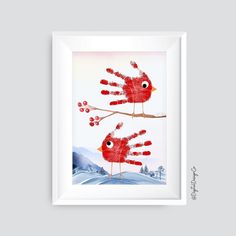 two red birds sitting on top of a tree branch with their hands in the air