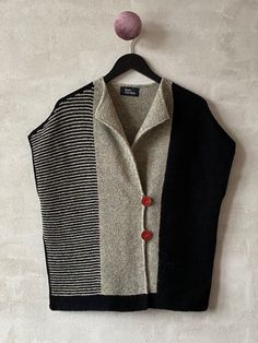 a sweater vest hanging on a wall with a ball attached to the top of it