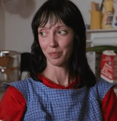 a woman in a blue and red dress is looking at the camera with an intense look on her face