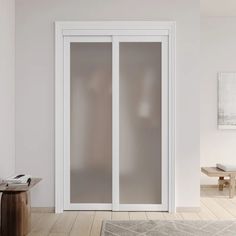 a white room with two sliding glass doors and a rug on the floor in front of it