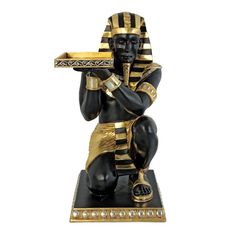 an egyptian figurine holding a tray with gold trimmings on it's face