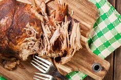 a piece of meat sitting on top of a cutting board next to a knife and fork