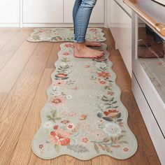 a woman standing on the kitchen floor in front of an oven with her feet up