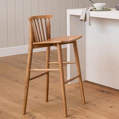 a wooden bar stool next to a counter